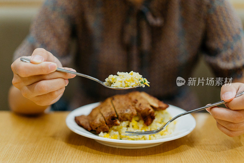 在餐厅吃蛋炒饭的亚洲女人