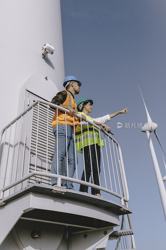 两名工程师在大流行期间在风电场工作风力涡轮机