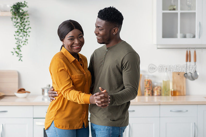 年轻快乐的黑人配偶一起在厨房跳舞，在家里玩得开心