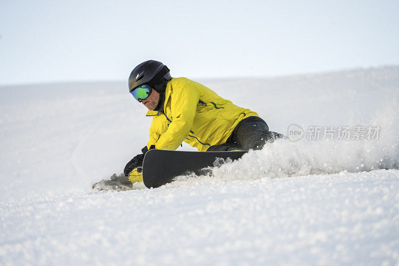 男子在滑雪板上切割滑雪坡