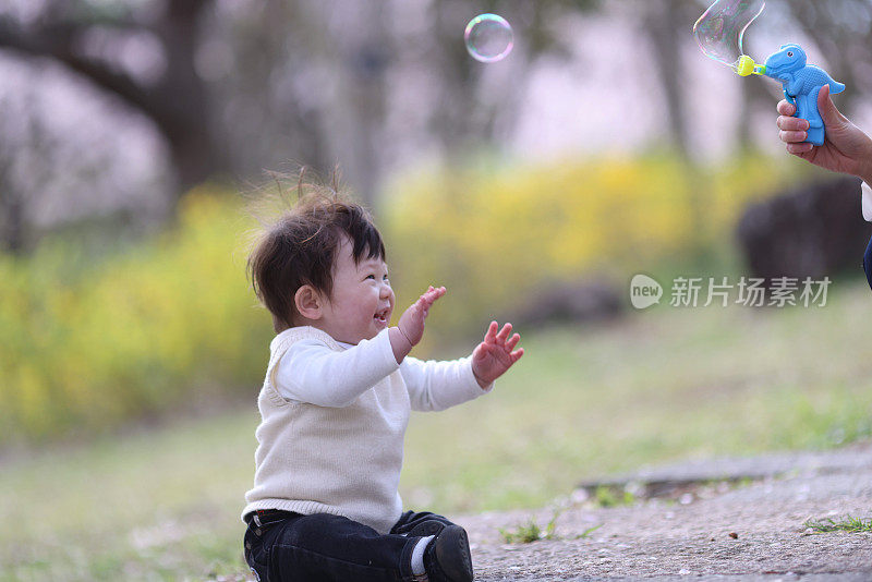 小孩子在樱花下玩泡泡