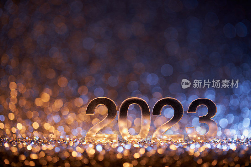 金光闪闪的数字2023上的金色和蓝色散焦灯-新年派对庆祝圣诞节