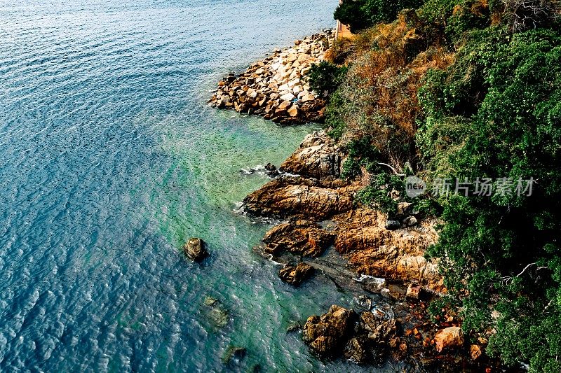 鸟瞰海浪、海滩、多岩石的海岸线和美丽的森林