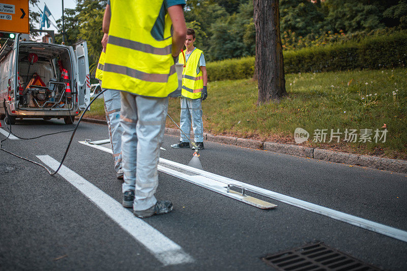 道路维修人员使用模板喷涂道路