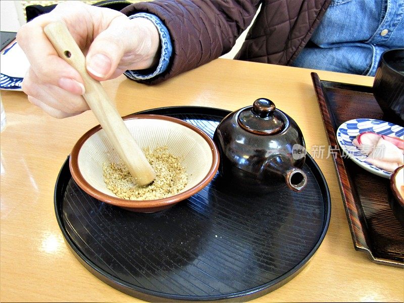 日本。准备牛肉排的酱汁。碾磨芝麻。