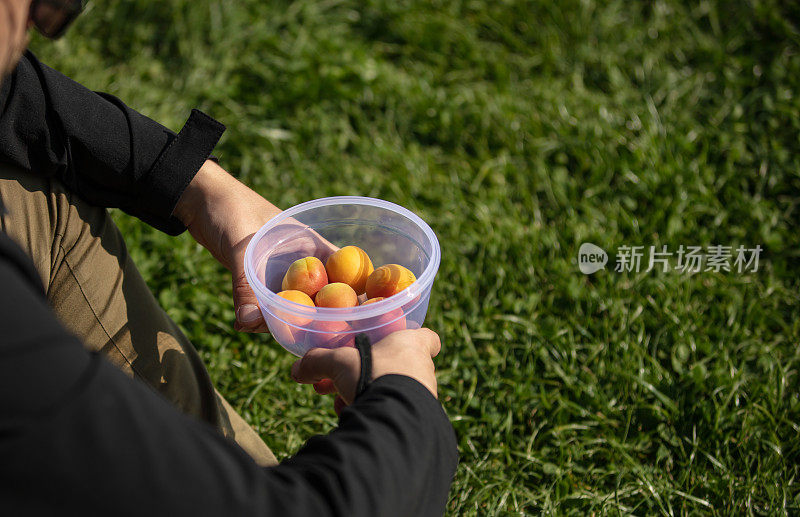 年轻人拿着一个塑料杯在外面。