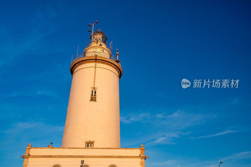 西班牙马拉加。沿着城市港口日落时的灯塔