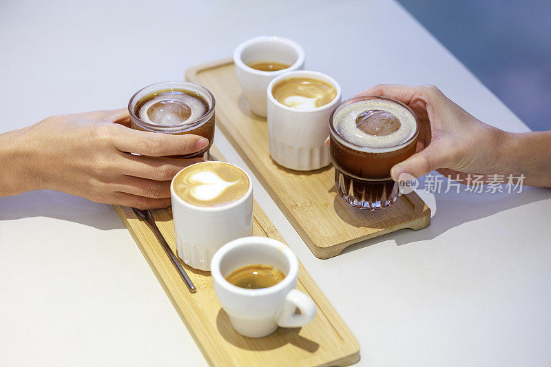 在一次咖啡测试活动中，一位技术娴熟的咖啡师在柜台上放了一个木托盘，巧妙地端上了三种不同的咖啡。托盘里有三个杯子，每个杯子里都有一种独特的咖啡——浓缩咖啡、拿铁咖啡和冰黑咖啡。