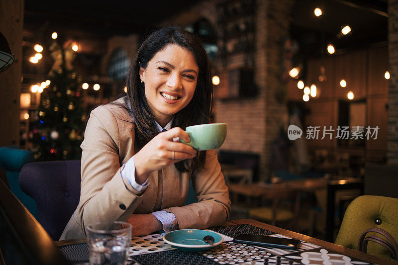 一位漂亮的年轻女子坐在酒吧里喝咖啡