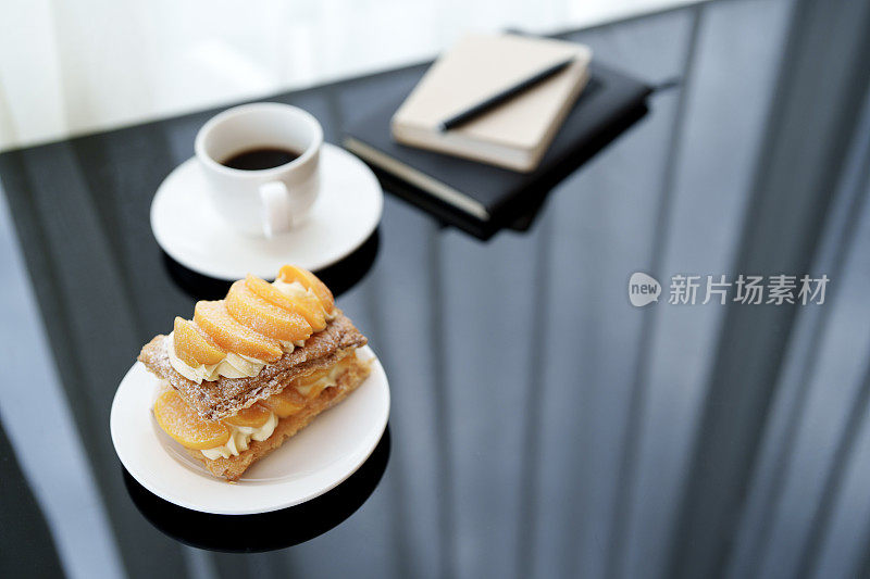 在舒适的咖啡馆里，桃子馅饼配上一杯浓郁的黑咖啡是完美的餐后甜点