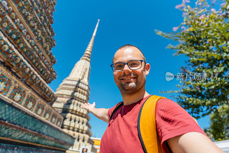 在泰国曼谷卧佛寺自拍的年轻人