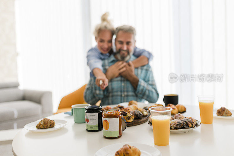 一对幸福的成熟夫妇在家里一起享用早餐的照片