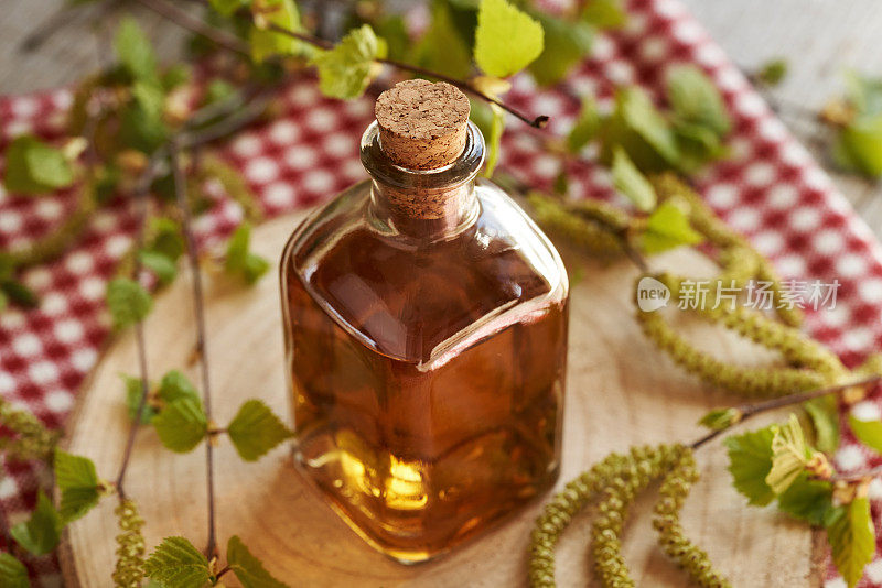 一瓶用春天收获的带有嫩叶和柳絮的桦树树枝制成的草药酊剂