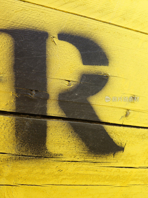 字母R画在黄色的木制背景上