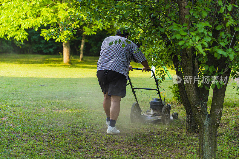 拿着割草机的人