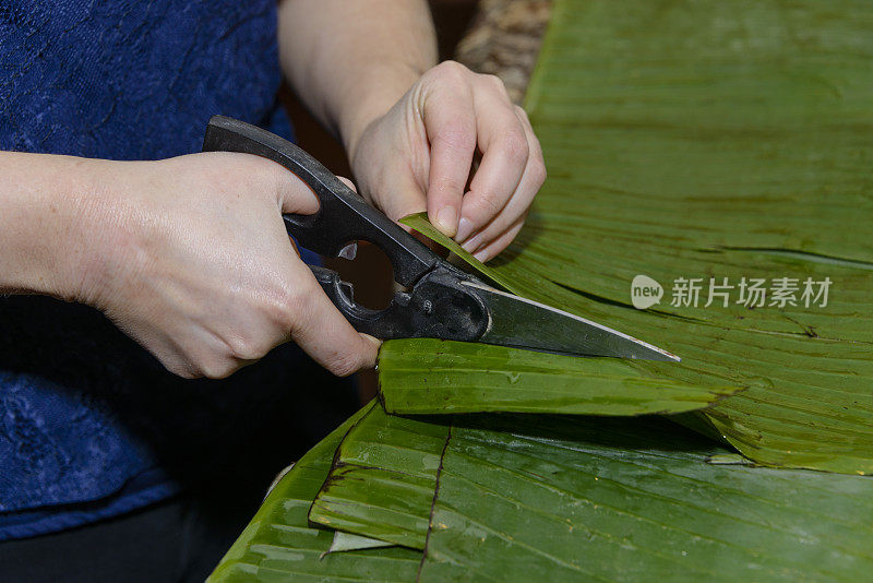 年轻女子正在切香蕉叶做玉米粉蒸肉