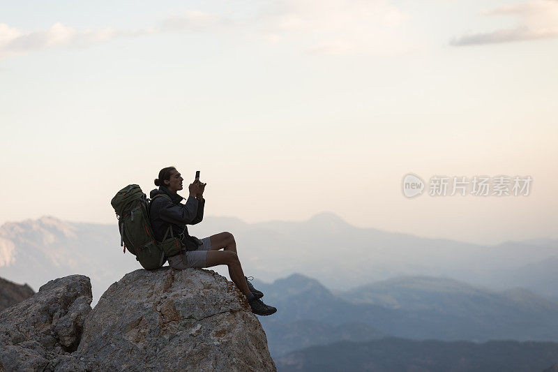 登山者在山顶使用智能手机