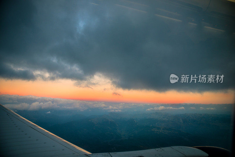 日落时飞机飞过群山