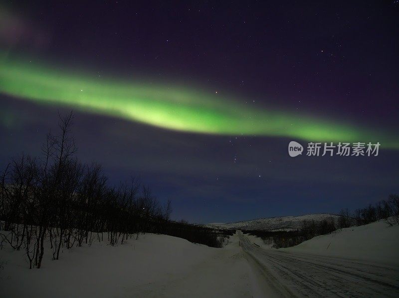 雪地上，北极光穿过猎户座