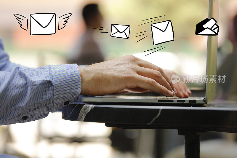 特写商人用电子邮件图标在笔记本电脑键盘上打字，电子邮件的概念
