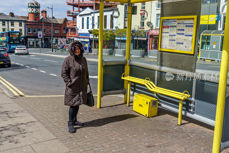 公交站的西班牙裔老妇人