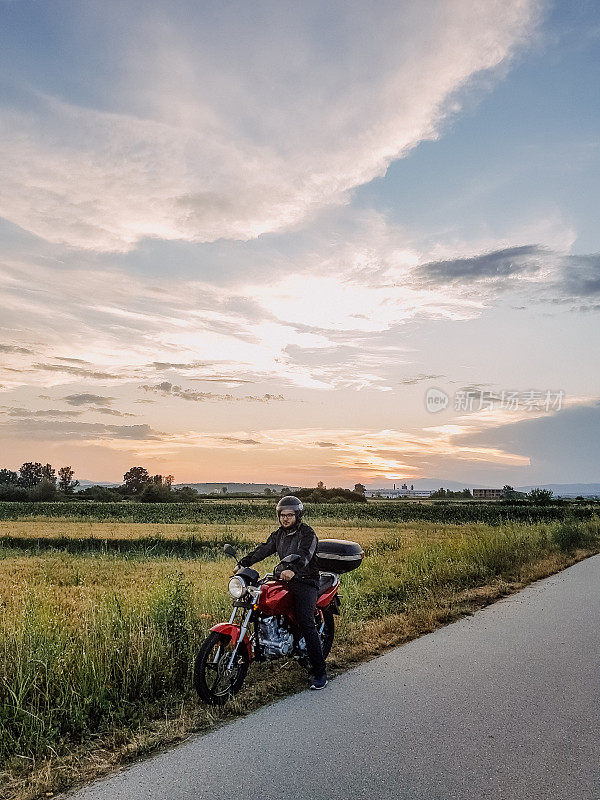 在乡村道路上骑摩托车的人