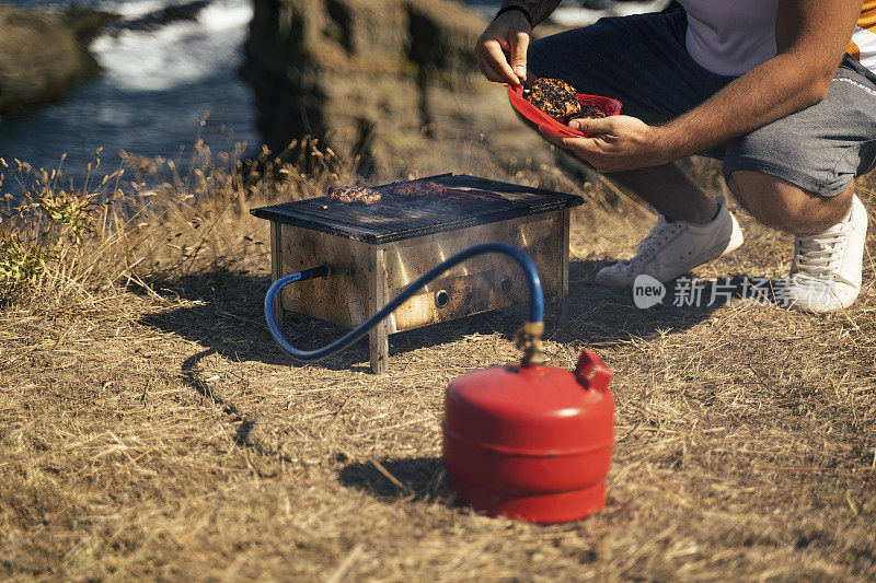 午餐时间用煤气炉做饭。野餐和汉堡的烧烤。