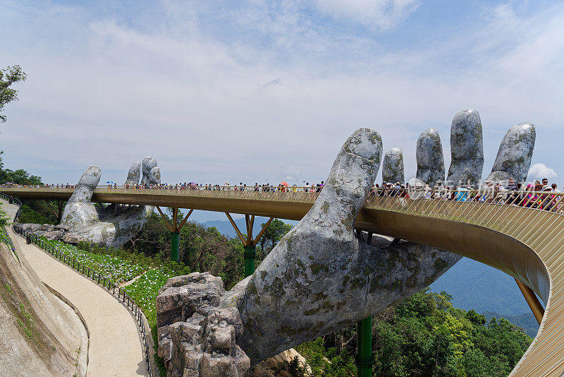走过金桥的游客被两只大手举起来。越南岘港巴那山度假胜地