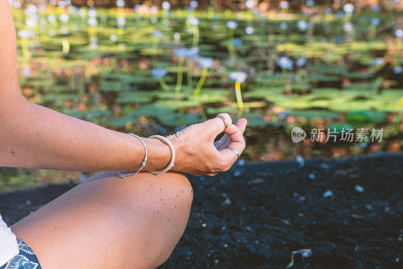 近距离的女人锻炼瑜伽莲花姿势接近睡莲花