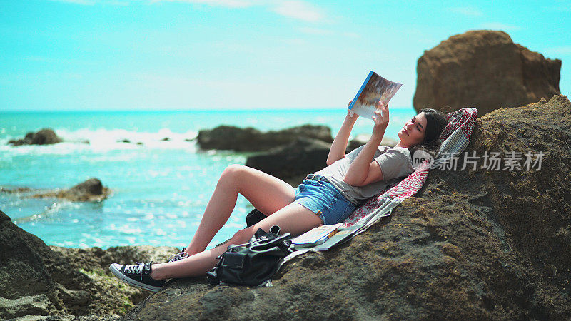 坐在海滩上看书的女孩