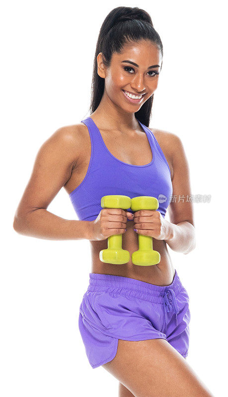 拉丁美洲和西班牙裔女性锻炼前的黑色背景，穿着运动胸罩和积极与重量