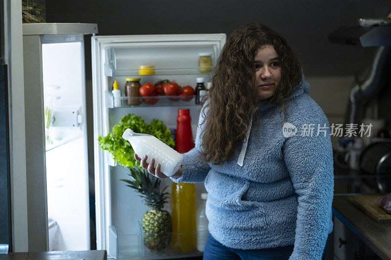 十几岁的女孩晚上偷偷从冰箱里喝东西