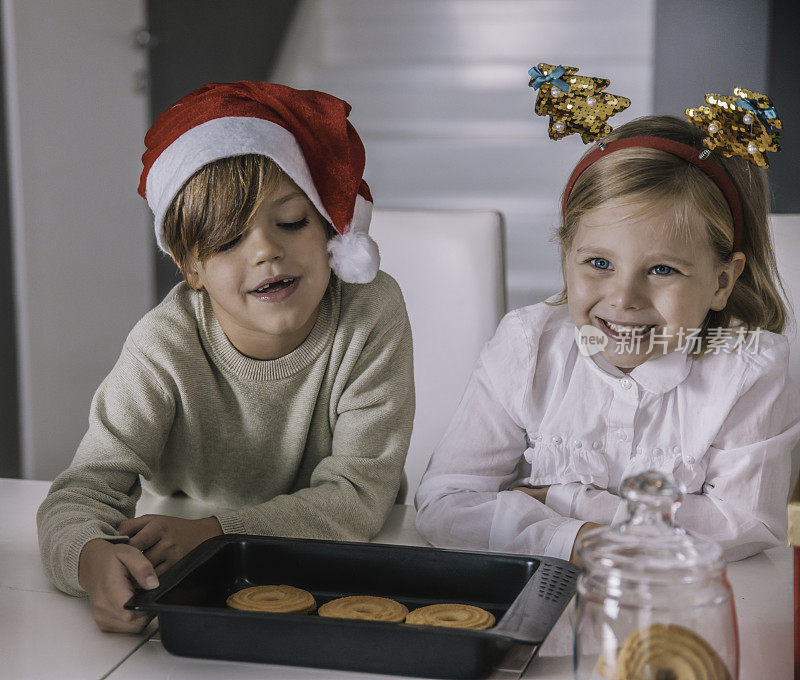 让我们为圣诞老人做圣诞饼干吧。圣诞老人的小帮手，快乐的家庭微笑的孩子们在厨房烤饼干