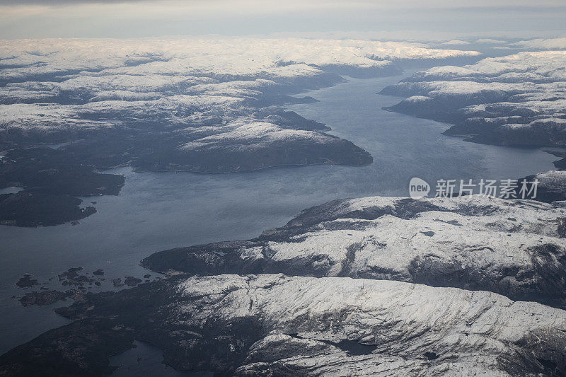 乘客从飞机上俯瞰挪威的峡湾，山上覆盖着积雪