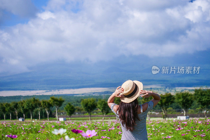 美丽的年轻女子在花圃休息