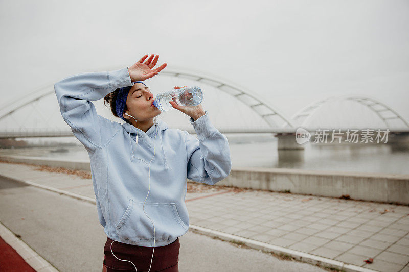 女性在饮水时去除前额的汗液