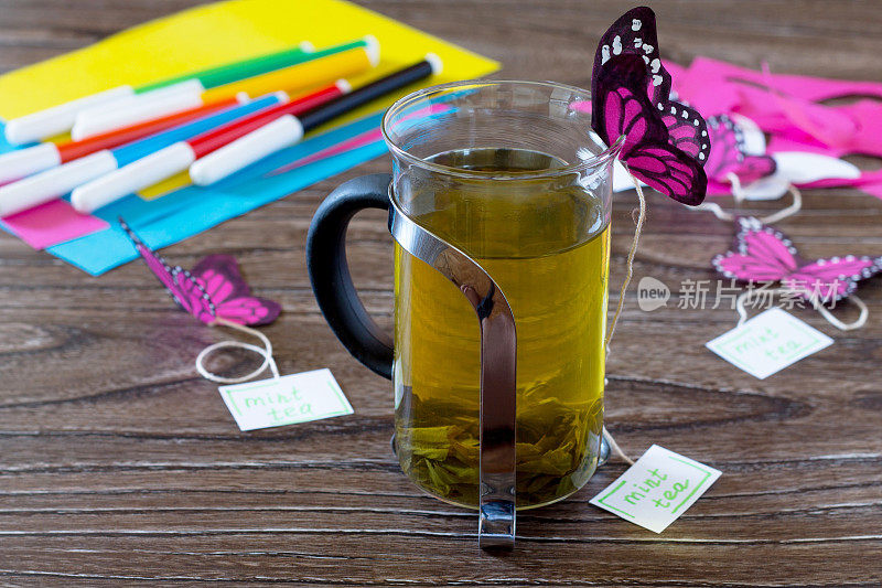 背景装饰纸蝴蝶在一杯薄荷茶。