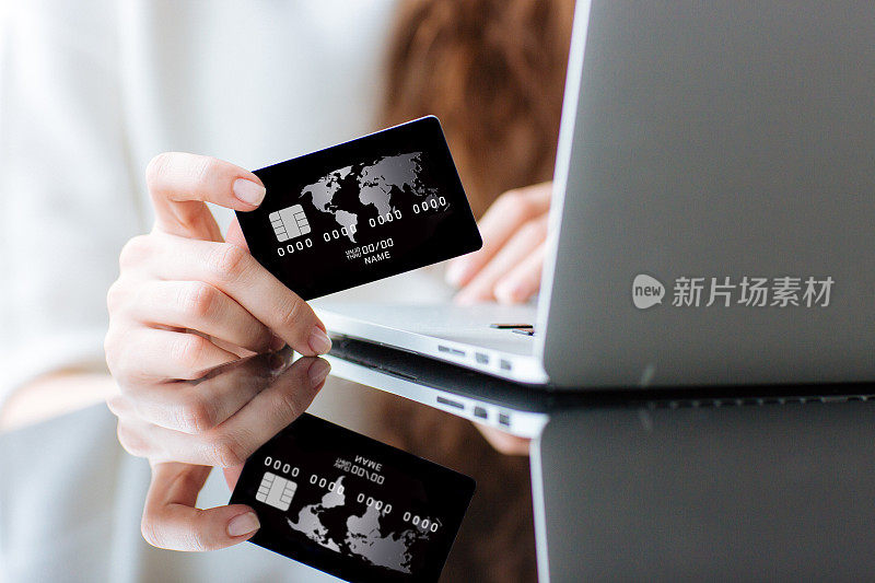 用信用卡在笔记本电脑上购物的女人