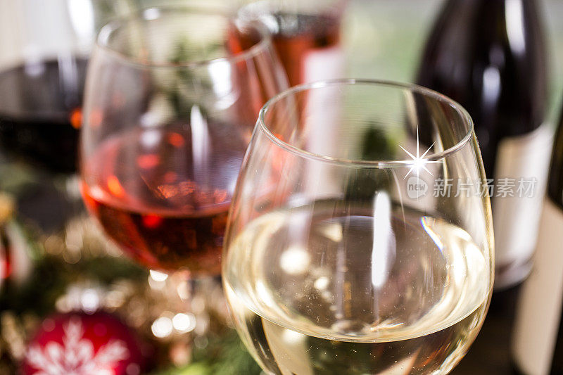 圣诞节餐桌上的酒杯里盛着各种各样的葡萄酒。