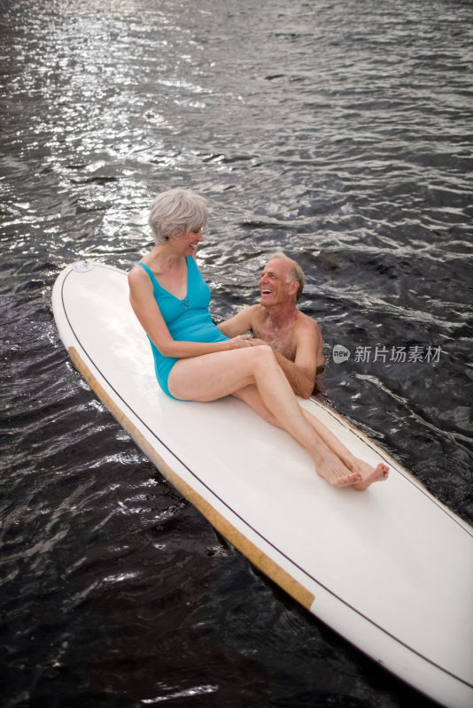 深情的老年夫妇与桨板在海上