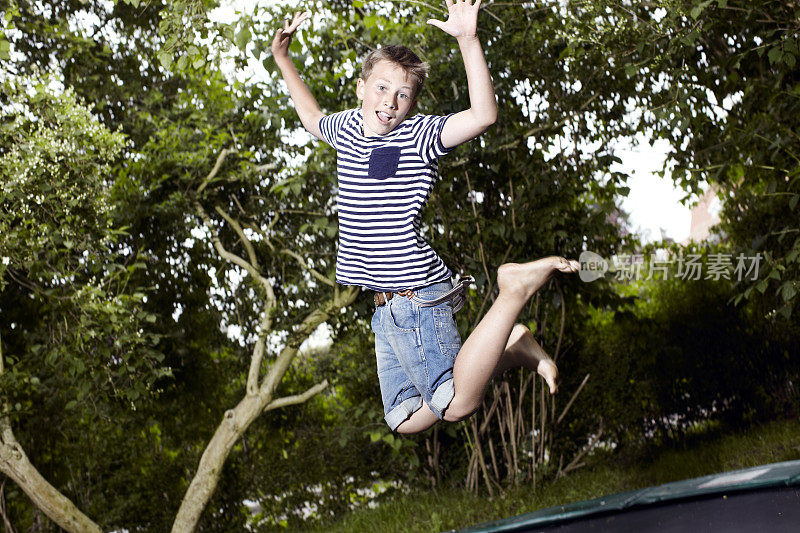 一个十几岁的男孩在蹦床上跳