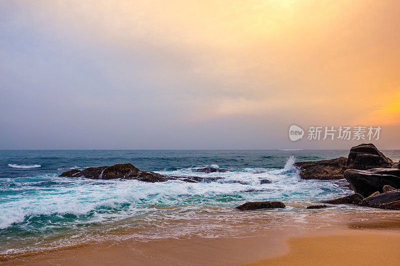 风景日落在岩石热带海滩。