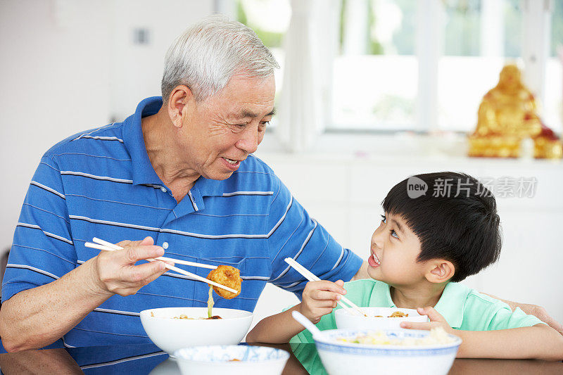 中国祖父和孙子一起吃饭的肖像
