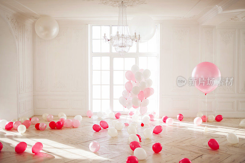 豪华的客厅，地板上有大窗户。宫殿里到处都是粉红色的气球