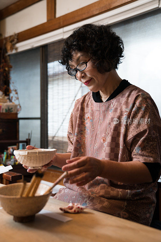 传统的日本手工艺妇女正在准备一个手工制作的纸碗