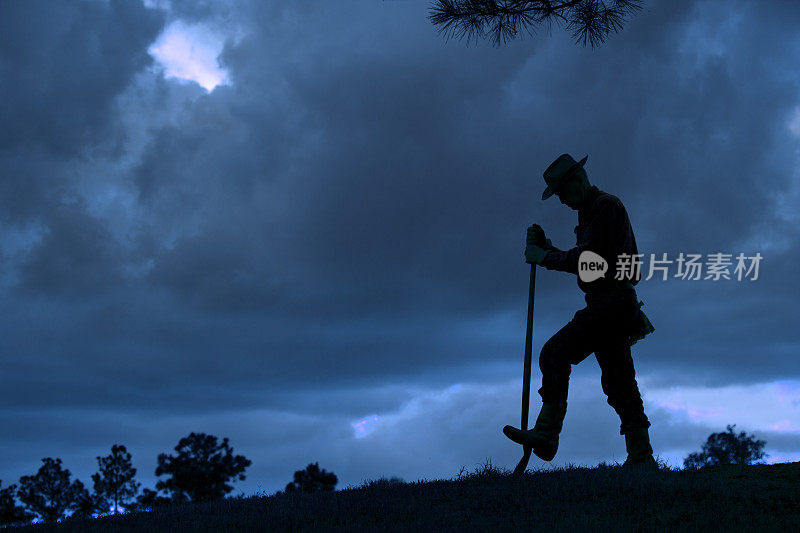 牧童:日落下暴雨后，俯瞰田野的农民剪影。