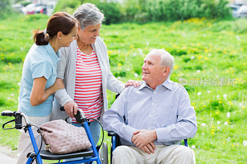 有轮椅和助行架的护理人员和老年夫妇