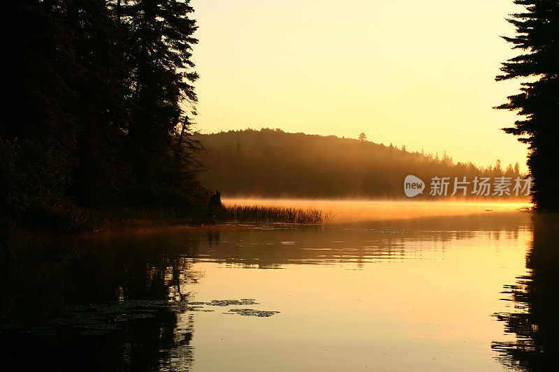 橘色的阳光照在平静如镜的湖面上