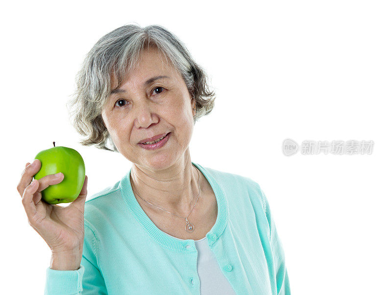 一位老妇人在白色背景下拿着苹果