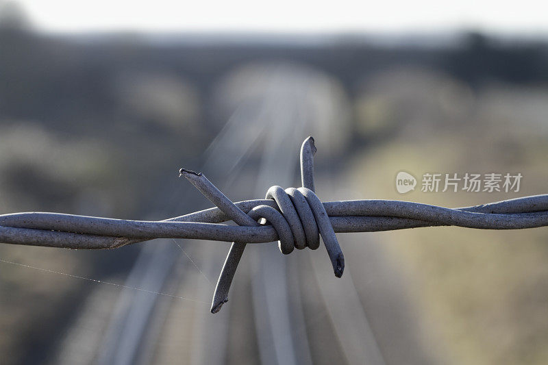 金属铁丝网与远处的铁路桥紧密相连